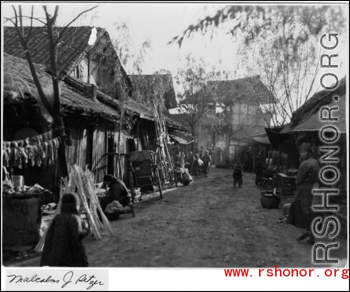 Market stall lining a small road in a Chinese village during WWII.  Photo from Malcolm J. Petzer.