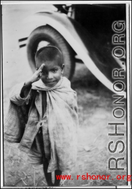A kid salutes the photographer in the CBI during WWII.