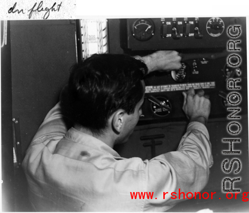 GI works a radio during flight in the CBI during WWII.