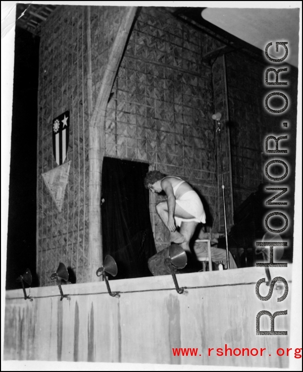 Cross-dressing GI removes an article of clothing while the band Jive-o-Lieps plays music in the CBI during WWII. 54th Air Service Group.