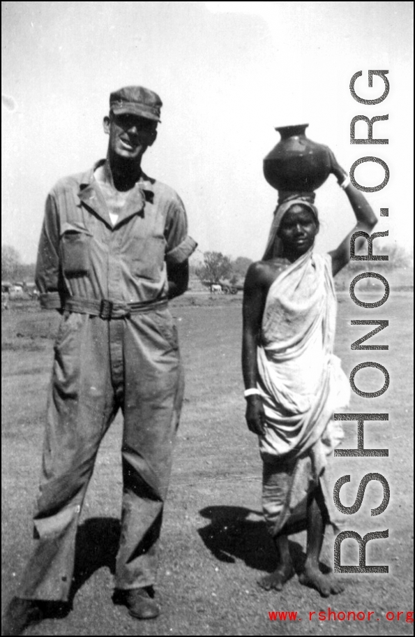 A GI and a woman carrying a pot on here head. India 1942 or 1943.