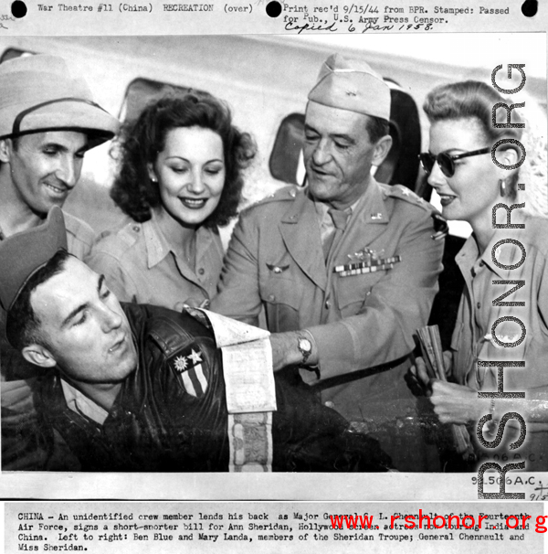 Chennault signs a "short-snorter" bill in the CBI while Hollywood stars look on--Ann Sheridan, Ben Blue, and Mary Landa.