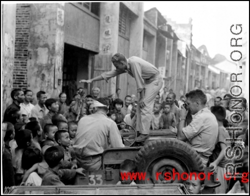 Capt. Grove campaigning for himself for mayor in a small town we passed through. Croughan on left, Capt. Penick on right.  Near an American base in Guangxi province (either Guilin or Liuzhou), China, during WWII.