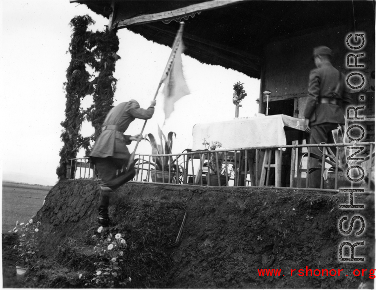 Chinese soldier climbs onto stage with banner during exercises in southern China, probably Yunnan province, or possibly in Burma.