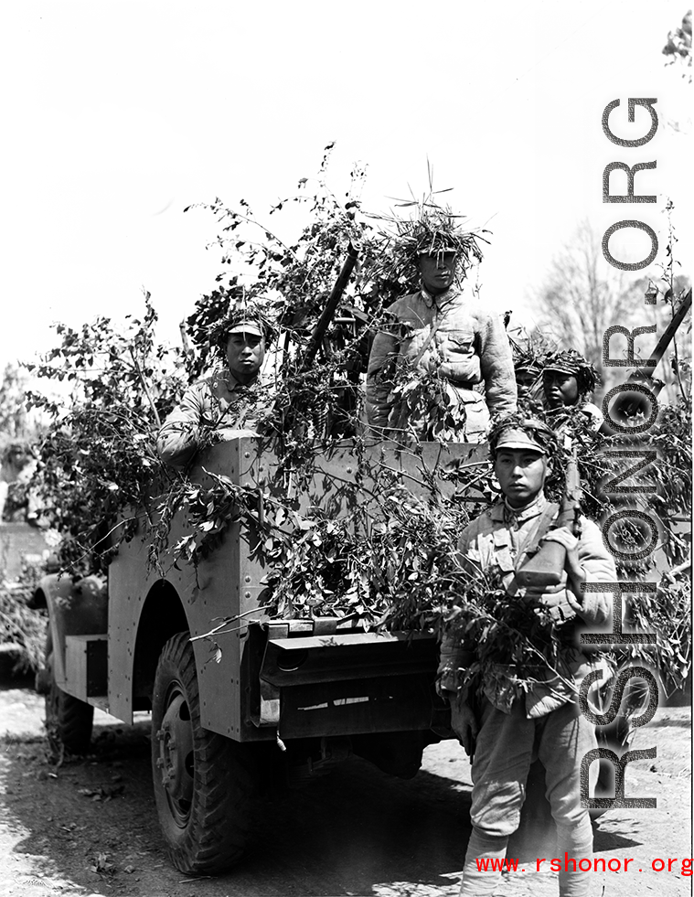 Chinese soldiers with equipment ready and covered in camouflage during exercises in southern China, in Yunnan province.  Despite the appearance of being on their way to battle, these men are more likely in fact prepared for a demonstration or honor parade. 