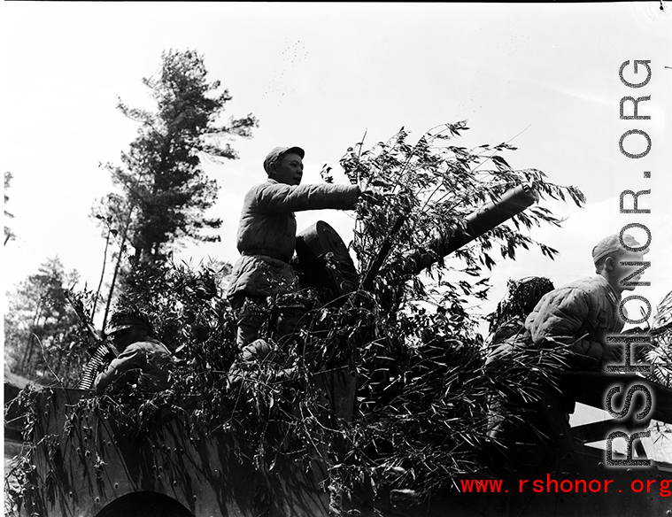 Chinese soldiers with equipment ready and American M3 Scout Car, covered in bamboo branches as camouflage, during exercises in southern China, in Yunnan province.