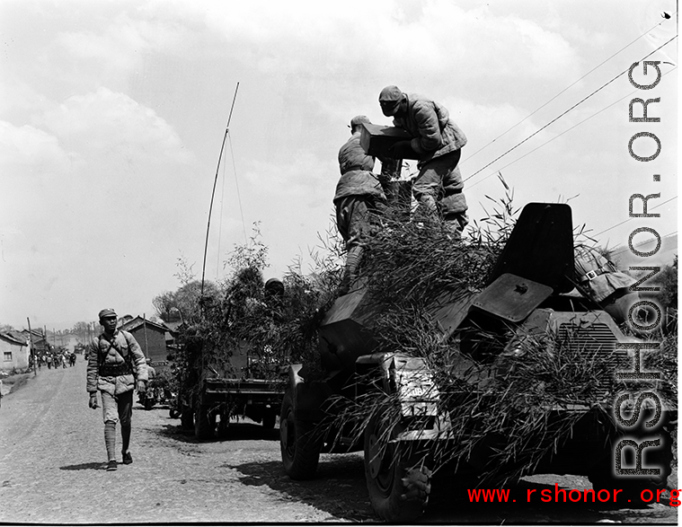 Chinese soldiers making final preparation on armored vehicles, and covered in camouflage during exercises in southern China, in Yunnan province.