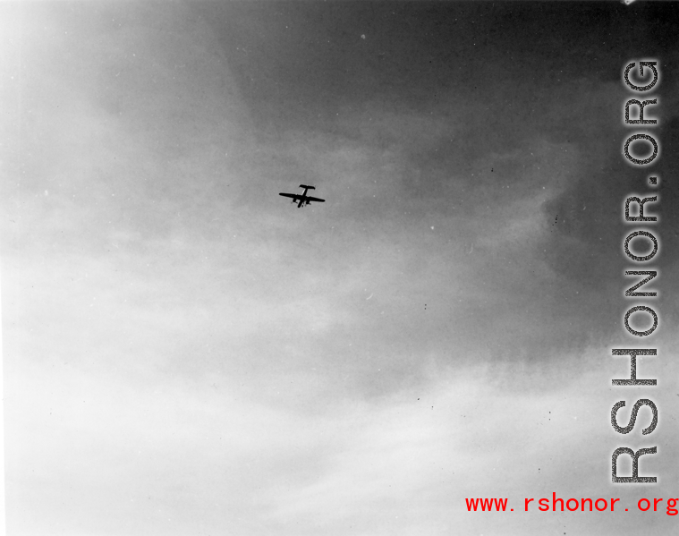 A B-25 Mitchell bomber high in flight in the CBI, in the area of southern China, Indochina, or Burma, during WWII.