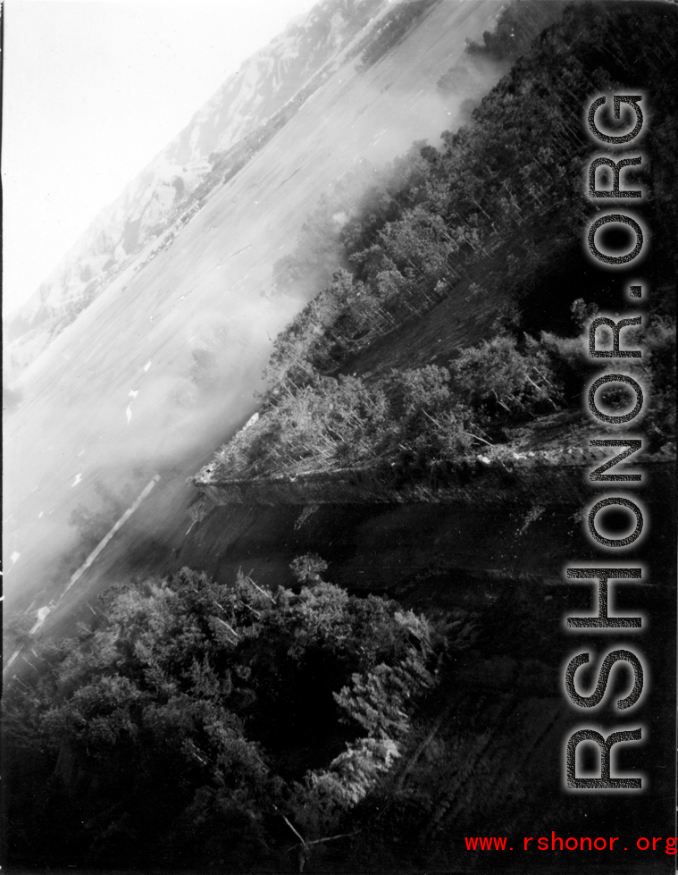 Smoke drifts over Tengchong city wall after B-25 Mitchell bomber attacl during battle with Japanese ground forces, flying over Tengchung (Tengchong), near the China-Burma border in far SW China.