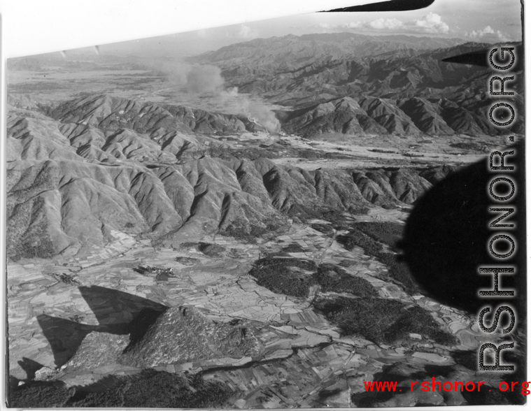 Smoke rises after attack by B-25 Mitchell bombers during battle with Japanese ground forces, flying in the rough area of Tengchung (Tengchong), near the China-Burma border in far SW China.