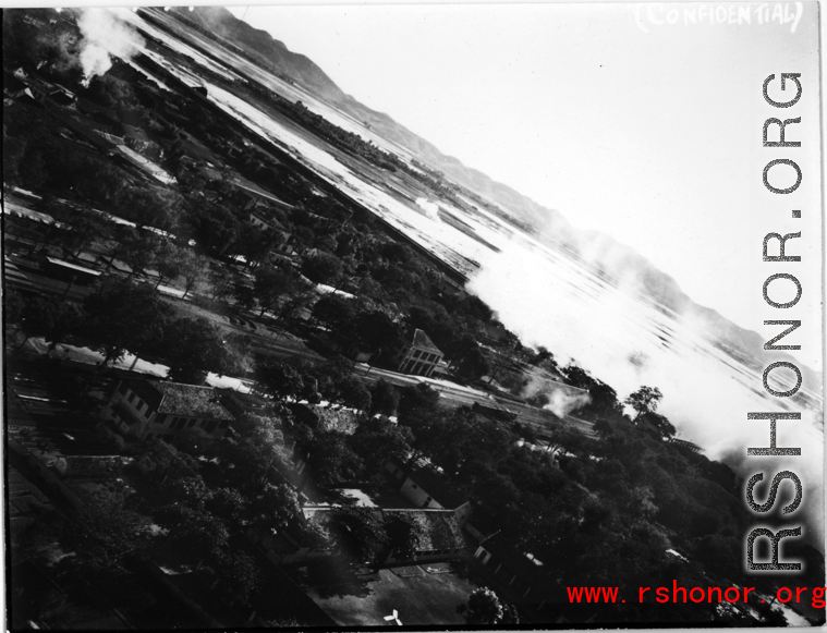 A railroad bridge is bombed on a river, probably in SW China, Indochina, or the China-Burma border region.