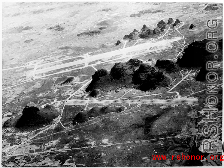 Runways among Karst peaks at the American base at Yangtong, Guilin, Guangxi province, China, during the Japanese occupation in late fall of 1944 until July 1945.  Bomb pits are visible in the runway in the foreground, which was blown up during the American evacuation to deny use to the incoming Japanese.