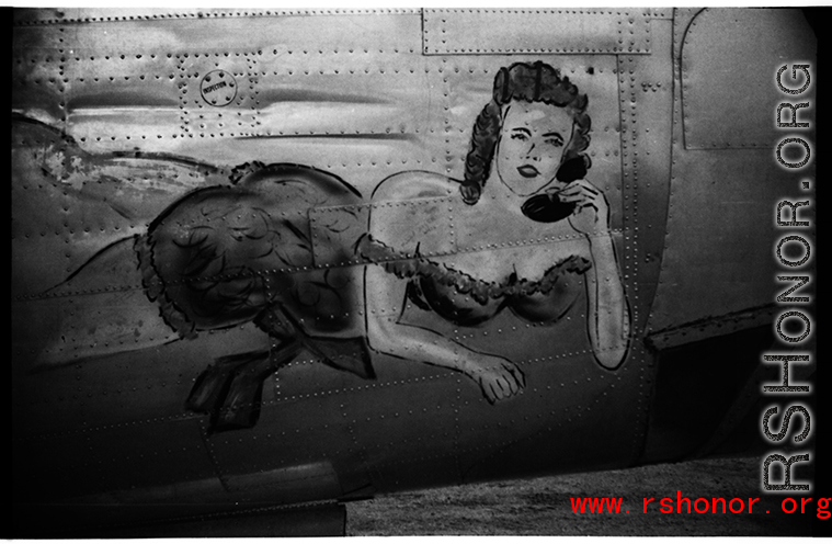 Nose art on a Consolidated B-24 bomber, of a buxom woman on the telephone. During WWII in China.