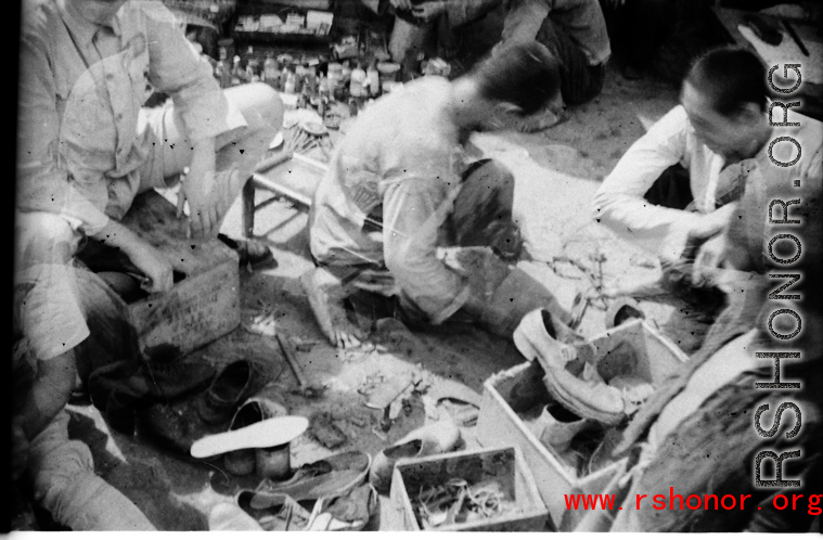 Streetside shoe repair in Yunnan, China, during WWII.