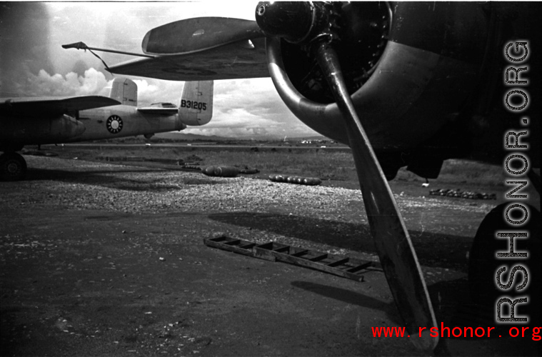 A B-25, tail number #B31205, with bombs laid out ready for loading, at the base. WWII in Yunnan province, China.