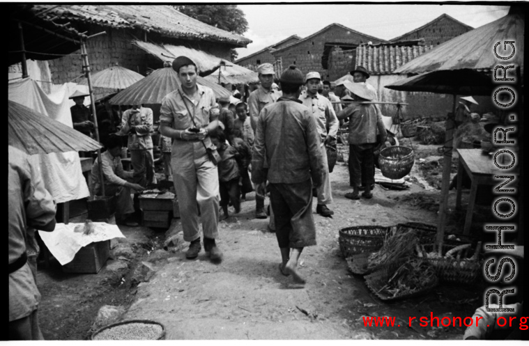 GI walking through market street at village near the American air base in WWII in Luliang, Yunnan province, China.