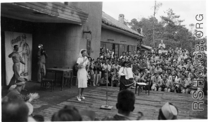 Celebrities (including Ann Sheridan in this shot) perform on an outdoor stage set up at the "Last Resort" at Yangkai, Yunnan province, during WWII. Notice both Americans and Chinese in the audience for this USO event.