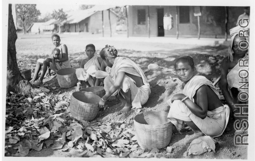 Women doing something with baskets.  Scenes in India witnessed by American GIs during WWII. For many Americans of that era, with their limited experience traveling, the everyday sights and sounds overseas were new, intriguing, and photo worthy.