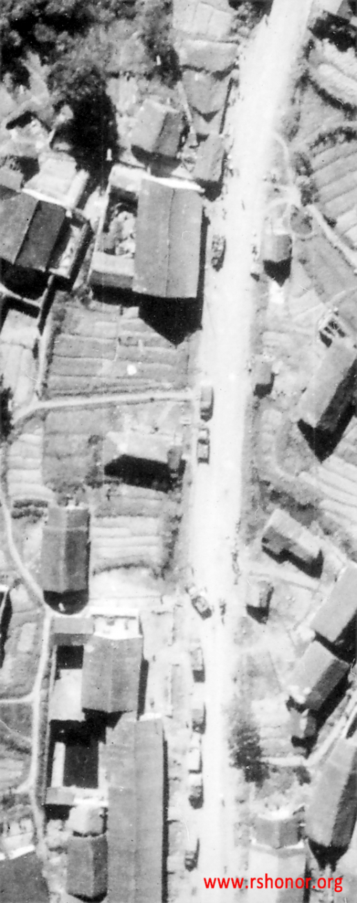 Trucks and soldiers of a Japanese convoy sparsely spread around a small town in Guangxi province, China, during WWII.  Notice the bombs falling in the upper left corner.