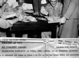 "Red Cross Girls" in China during WWII. Peg Pagenkopf and Mimi Buecher distribute bingo prizes to to S/Sgt. H. D. Frye, S/Sgt. Jos H. Cortner, Tsong Tsen Kwo, and Orville D. Benson.