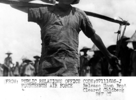 Young girl shoulders carrying-pole to repair runway at Liuzhou, Guangxi province, in the CBI, after Japanese retreat after Ichigo.