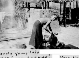 Lovely young lady in Mengsa or Szemao laddling liquid from an earthenware container. 1944.