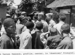 Lt. Vernon Swanson, profile, center, in downtown Qionglai (Kiunglai), China, about 30 miles from Chengtu, during WWII. GI were with the 462nd Bomb Group, 768th Squadron (B-29s).