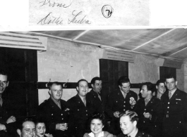 Dorothy Leuba and Elizabeth May surrounded by attentive GIs at a party and dance at the Hostel #10 Officer's Club on January 19, 1945. Seated to left is also Sam Gale, and to right, Tom Angel.  Image provided by Dorothy Yuen Leuba.