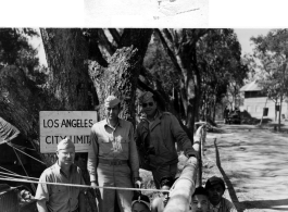 GIs pose with squatting men in the CBI, likely Japanese POWs.  Photo processed by 164th Signal Photographic Company.