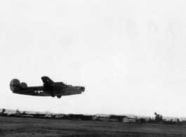 A B-24 in the air over a runway in the CBI during WWII.  Image provided by Emery and Beth Vrana.