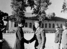 GIs shake hands during citation ceremony in China during WWII.  Image provided by Emery and Beth Vrana.