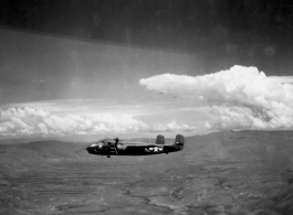 A 491st Bomb Squadron B-25H, tail #439, in formation flight somewhere over China. Look carefully above the tail to see two more B-25s just below the large cloud.