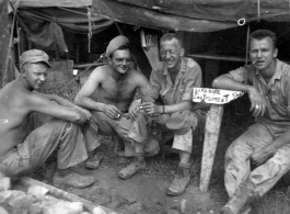 GIs in front of instrument shop tent in Liangshan, China: "This Motley Crew Is Goofing Off In Front Of Our First Class Instrument Shop In Liangshan, China. Left To Righ: Steenrod, Brantl, Wolfe, and Bukey."