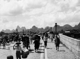 Bustling city life on a bridge in Guilin during WWII.