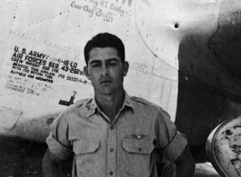 A man poses before the F-5 (a variant of the P-38) 'Mary Ann' piloted by Major H. T. Bailey, who had a crew chief "Snaffy".