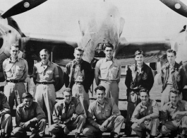 Men from the 21st Photographic Reconnaissance Squadron pose for a group shot in front of an F-5 (a variant of the P-38).