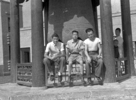 GIs of SACO and a Chinese soldier sit in front of a large cast bell, next to the Lanzhou City Hospital (兰州市立医院) in Gansu province, China, during WWII.