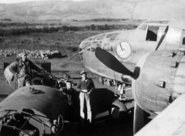 Early in the morning on a spring day in 1945, 491st Bombardment Squadron personnel (mechanics- Schumaier, Scott; armorer- ?) prepare a B-25D, #42, for a mission. The top of the fuel truck is in the foreground of the revetment at Yangkai AB. When the aircraft were dispatched to 'forward operation' bases they were often fueled with hand pumps from 50-gallon drums. Francis Strotman, flight engineer, told of using five-gallon 'jerry cans' to transfer fuel from a C-46 transport to his B-25 in order to have enoug