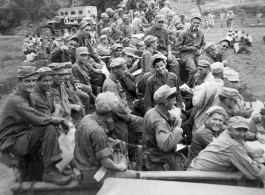 7th Veterinary Company GIs packet tightly into train cars for transport. A Red Cross "Clubmobile" truck is parked on a road in the background. During WWII in the CBI.