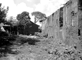 Adobe back wall of a large building. Local scenes and local people in Yunnan province, China, most likely around the Luliang air base area.