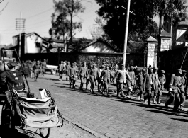 Chinese soldiers walking on a road in Kunming during WWII.