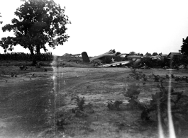 Wrecked B-25 Mitchell bomber on the ground in the CBI. The wreck was apparently at an air base, and probably on take-off, as the craft is sprayed with fire-retardant foam, and bombs are scattered about the wreck site. During WWII.