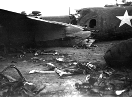 Wrecked B-25 Mitchell bomber on the ground in the CBI. The wreck was apparently at an air base, and probably on take-off, as the craft is sprayed with fire-retardant foam, and bombs are scattered about the wreck site. During WWII.