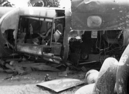 Wrecked B-25 Mitchell bomber on the ground in the CBI. The wreck was apparently at an air base, and probably on take-off, as the craft is sprayed with fire-retardant foam, and bombs are scattered about the wreck site. During WWII.