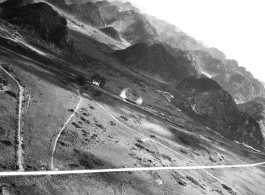 Smoke or steam arises from two railway cars in SW China, French Indochina, or Burma, in the CBI, during WWII, among karst peaks.