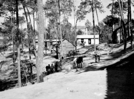 GI explorations of the hostel area at Yangkai air base during WWII: Local people move between the trees and buildings on the base.