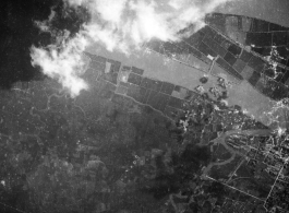 Explosions during bombing of small riverside town in either SW China (esp. Guangxi),  Burma, or French Indochina. During WWII. Signs of previous bombings are visible about, including bomb craters here and there.