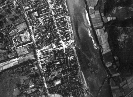 Bombing of small riverside town likely in SW China (esp. Guangxi), but possibly in Burma, or French Indochina. During WWII. Signs of previous bombings are visible about, including destroyed houses along the main road, and bomb craters here and there.