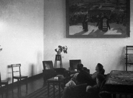 GIs rest in a nice room, under a large portrait of a Tibetan pilgrimage to a Tibetan Buddhist temple.  Probably in Lanzhou or nearby. During WWII.