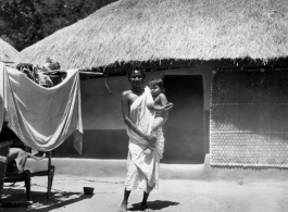 Woman holding child.  Scenes in India witnessed by American GIs during WWII. For many Americans of that era, with their limited experience traveling, the everyday sights and sounds overseas were new, intriguing, and photo worthy.